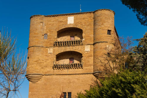 Torre histórica de ladrillo en el centro de Benavente con balcones arqueados y cielo azul despejado