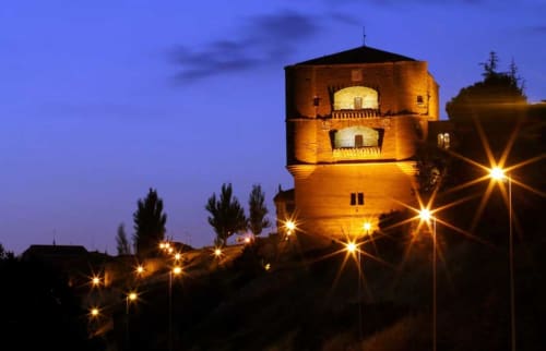 Torre histórica iluminada al atardecer en Benavente con farolas y cielo crepuscular