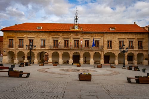 Ayuntamiento histórico con arcos en la plaza central de Benavente, con tejado de terracota naranja y fachada de piedra