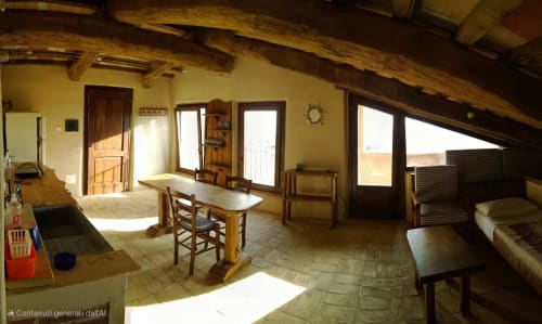 Ampio appartamento a Casale di Poggioferro con travi in legno, arredamento rustico e luminosa luce naturale da ampie finestre