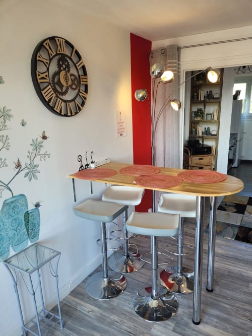 Bar de cuisine moderne à l'appartement Val'Déco aux Ponts de Cé avec table en bois, tabourets blancs et décor industriel