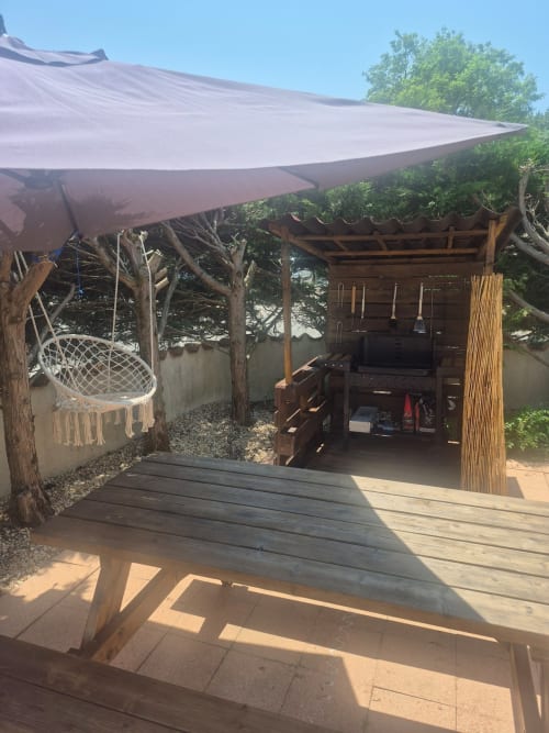 Terrasse de jardin avec hamac, pergola en bois et voile d'ombrage à l'appartement Val'Déco aux Ponts de Cé