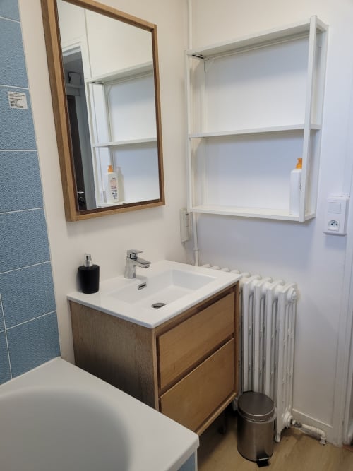 Salle de bain contemporaine à Val'Déco Conciergerie avec meuble vasque en bois, rangements blancs, carrelage mural et radiateur