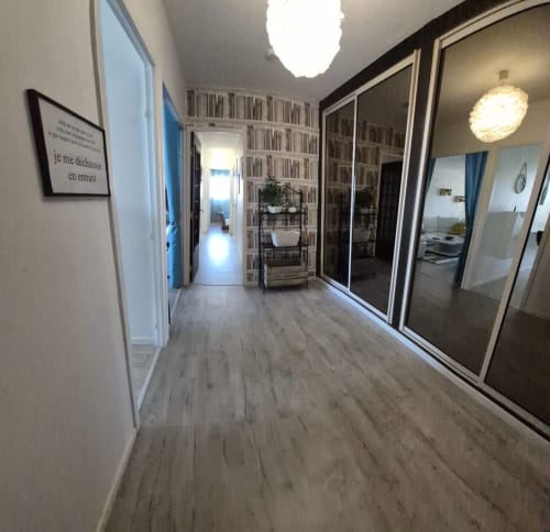 Couloir moderne de l'appartement Val'Déco Conciergerie, Les Ponts de Cé, avec parquet clair, bibliothèque et armoire coulissante
