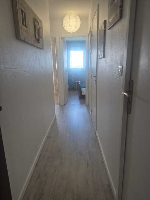 Couloir contemporain de l'appartement Val'Déco aux Ponts de Cé avec parquet et suspension globe
