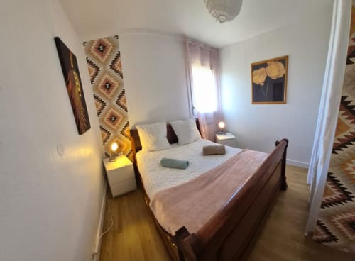 Chambre douillette à Val'Déco Conciergerie aux Ponts de Cé avec lit en bois, literie blanche, décoration murale et ambiance chaleureuse