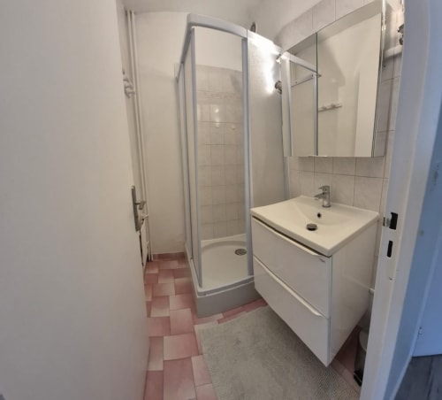 Salle de bains moderne avec douche, vasque blanche et carrelage terracotta chez Val'Déco Conciergerie, Les Ponts de Cé