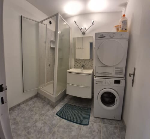 Salle de bain moderne avec douche, lavabo et lave-linge superposé, appartement Val'Déco, Les Ponts de Cé