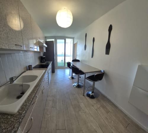 Kitchenette moderne à l'appartement Val'Déco aux Ponts de Cé avec électroménagers en inox, table à manger, vue sur la ville