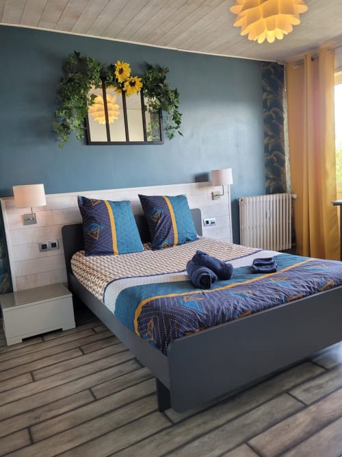 Chambre moderne à Val'Déco Conciergerie, Les Ponts de Cé avec murs bleus, décoration tournesol et literie à motifs
