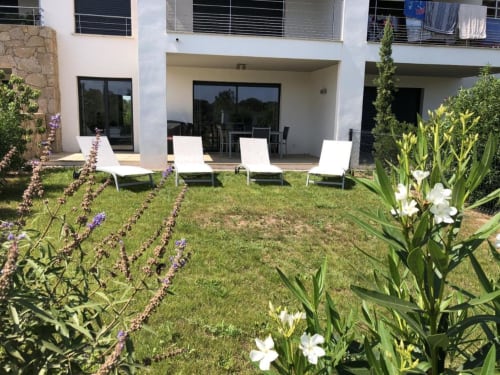 Charmant jardin de fête avec chaises longues, fleurs de lavande et architecture moderne à Porto-Vecchio