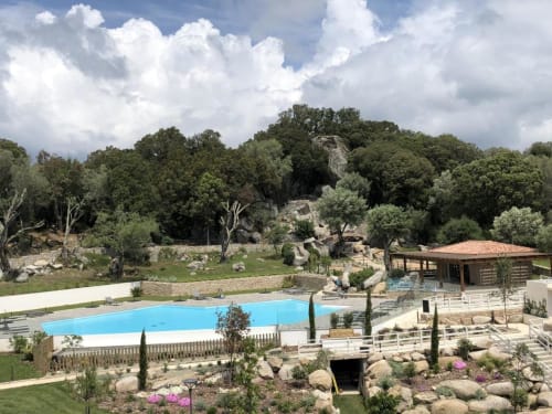 Piscine et jardins Sweet Holiday à Porto-Vecchio avec piscine turquoise, bâtiments en pierre et paysage méditerranéen