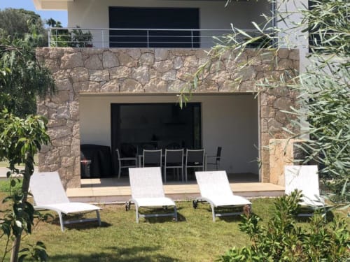 Apartment Elegance at Sweet Holiday in Porto-Vecchio features a stone terrace with white loungers and garden views