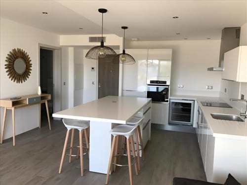 Modern kitchen and dining area in Apartment Allure at Sweet Holiday, Porto-Vecchio with island seating and pendant lights
