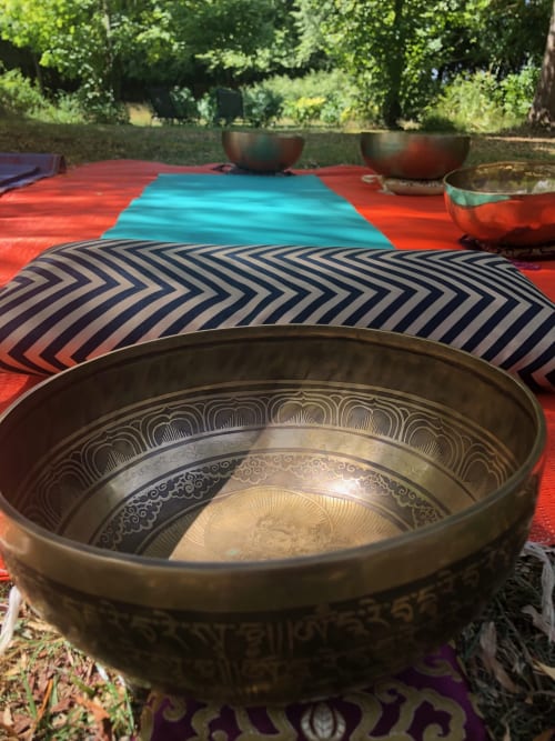 Decorative singing bowls on colorful mats at Domaine de l'Ocrerie wellness retreat in Pourrain, France