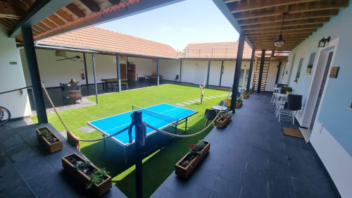 Blue ping pong table on green artificial grass in covered courtyard at Eco Charm Discovery villa in Leiria, Portugal