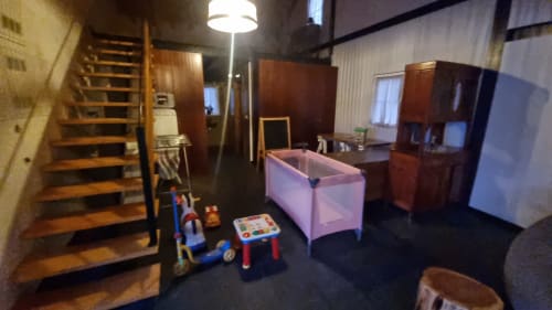 Leiria villa playroom with wooden stairs, pink portable crib, toys, and wooden furniture at Charm Discovery Experiences