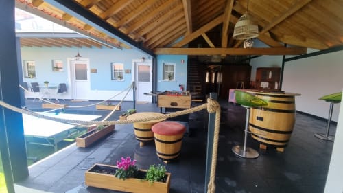 Intérieur de l'appartement Casa do Lume à Charm Discovery Experiences à Leiria avec sièges en tonneau, détails en corde et accents côtiers bleus