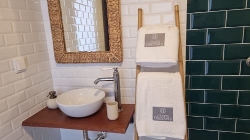 Salle de bain moderne à Casa do Lume à Leiria avec carrelage blanc subway, vasque en bois, miroir à cadre tissé et serviette blanche