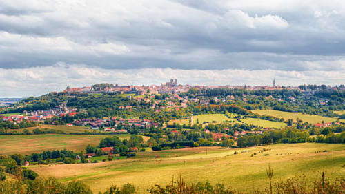 Paysage de campagne vallonnée avec petite ville perchée à l'horizon près de Doncourt-sur-Meuse, France