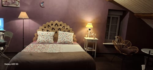 Chambre douillette à La Maison de Marie-Claire B&B à Doncourt-sur-Meuse avec murs violets, tête de lit décorée et vue sur le jardin.