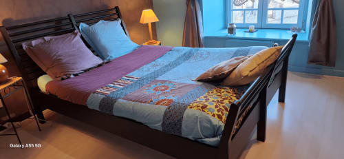 Chambre douillette à La Maison de Marie-Claire B&B à Doncourt-sur-Meuse avec parure colorée, lit en bois et jardin bleu