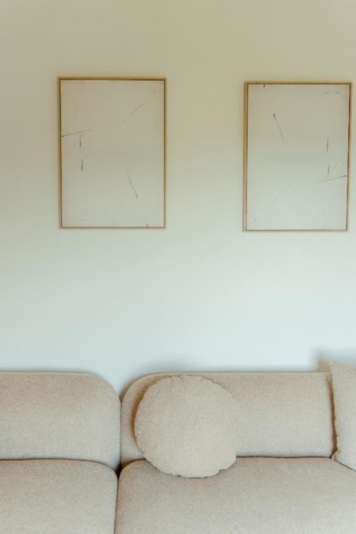Interno minimalista di un'abitazione rurale con opere d'arte incorniciate sopra il divano beige a Tenuta Alela, Figline Valdarno