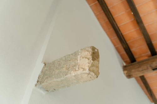Travi a vista e dettagli in pietra rustica nell'appartamento Barn di Tenuta Alela, Figline Valdarno