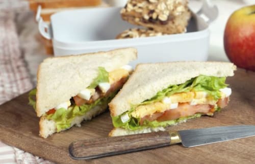 Club sandwich con lattuga, pomodoro e formaggio su pane bianco presso Porta Tosa B&B Milano, servito con biscotti e mela