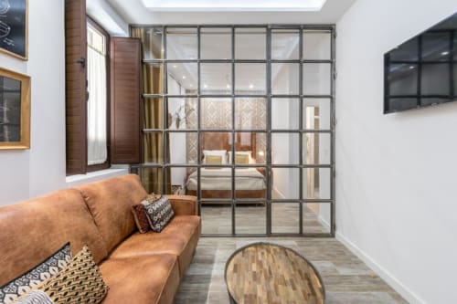 Apartamento loft moderno en CTH Granada con sofá de cuero coñac, puertas correderas negras y TV pantalla plana en Granada