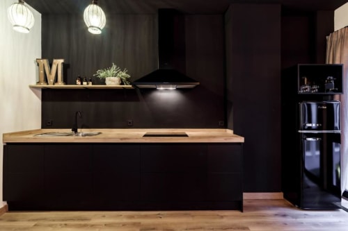 Cocina moderna negra con encimera de madera en el Apartamento CTH Granada Green, Granada