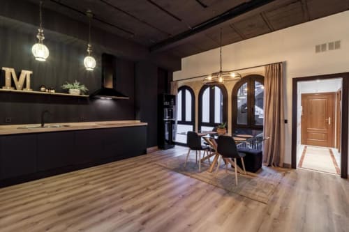 Cocina abierta moderna y sala de comedor en Apartamento CTH Granada Green con muebles negros, piso de madera y vistas a la ciudad