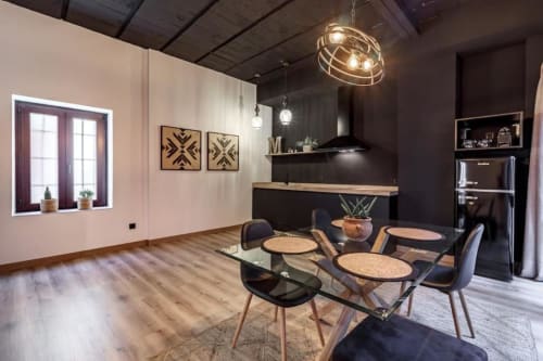 Cocina y comedor moderno en el Apartamento CTH Granada Green, Armilla, con muebles negros, mesa de cristal y vistas a la ciudad