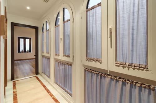 Moderno pasillo del Apartamento Green en el hotel CTH Granada con ventanales arqueados, cortinas claras y suelos de madera en Armilla