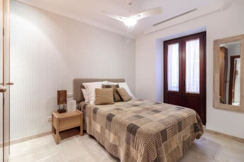 Dormitorio moderno en Apartamento CTH Granada Green, Armilla con cama queen, mesita de noche de madera, puertas oscuras, ventilador de techo y vistas de la ciudad