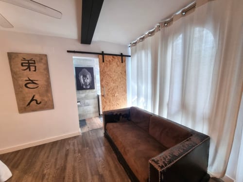 Sala de estar moderna en el Penthouse Gracia de CTH Granada con sofá de cuero marrón, suelos de madera y cortinas blancas con vistas