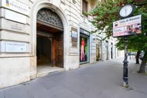 Affascinante ingresso con strada in sanpietrini della Guest House AD Trastevere a Roma, con muri ricoperti di edera e portale ad arco