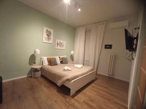 Camera moderna con letto matrimoniale, pareti verdi e pavimento in legno presso AD Trastevere Guest House a Roma