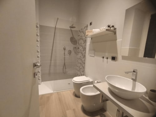 Bagno moderno presso l'AD Trastevere Guest House Roma con doppi lavabi a bacinella, doccia walk-in e finiture contemporanee