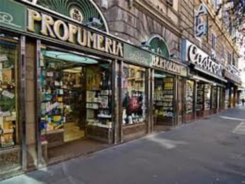 Facciata della AD Trastevere Guest House a Roma, con insegna verde e vetrine su una strada cittadina
