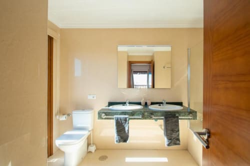 Baño moderno en Villa Cavendish, Playa Blanca con doble lavabo, inodoro y acceso a vista marina