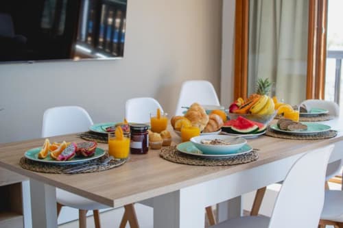 Desayuno en el comedor de Villa Cavendish con frutas frescas, pasteles, jugo y platos turquesas con vista a Playa