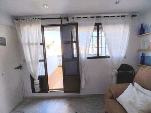 Luminoso dormitorio con puertas dobles abiertas hacia balcón con vistas al emblemático Jerez de la Frontera