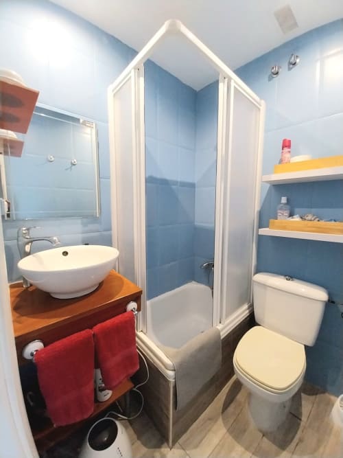 Baño moderno en apartamento Top Home Integra en Jerez de la Frontera con azulejos azules, lavabo redondo y ducha abierta