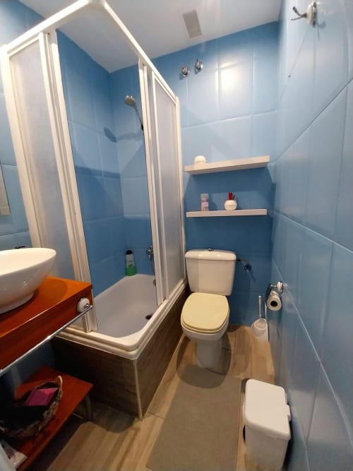 Baño moderno en apartamento Top Home Integra, Jerez de la Frontera, con paredes de azulejos azules, ducha, inodoro y
