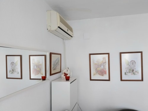 Interior moderno de apartamento con láminas arquitectónicas enmarcadas, unidad de aire acondicionado y elementos decorativos en Top Home