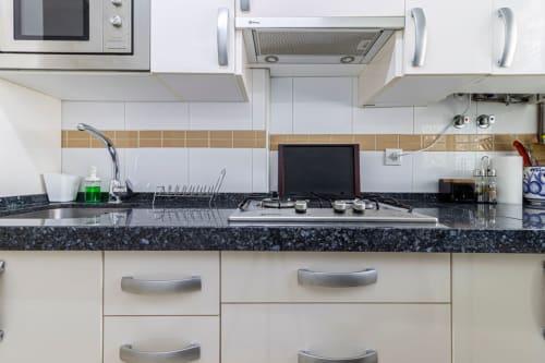 Cocina moderna en apartamento Top Home Integra, Jerez de la Frontera, con estufa a gas, encimeras de granito oscuro y blanco