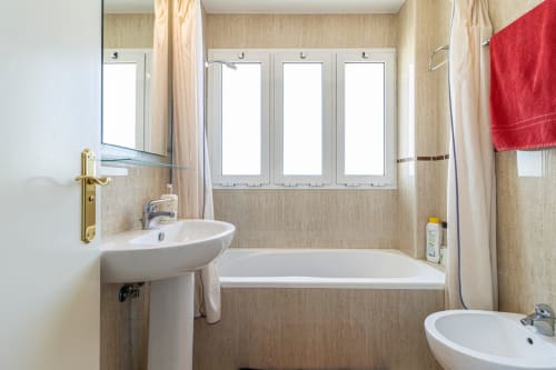 Baño moderno en apartamento Top Home Integra, Jerez de la Frontera, con doble lavabo, bañera y ventanas esmeriladas