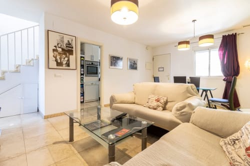 Moderno salón de apartamento en Top Home Integra en Jerez de la Frontera con muebles beige y vistas a la ciudad