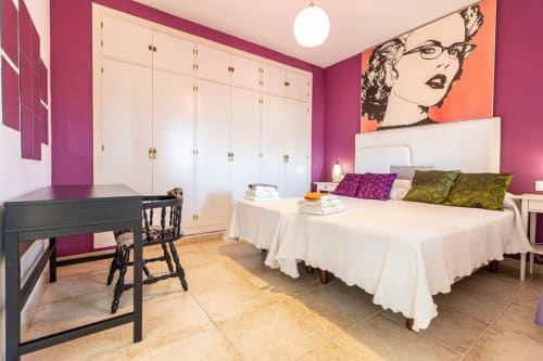 Dormitorio moderno en Top Home Integra, Jerez de la Frontera, con paredes magenta, cama blanca y decoración pop art
